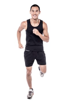 Happy young man hearing music while jogging