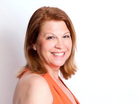 middle aged woman wearing orange dress on white background