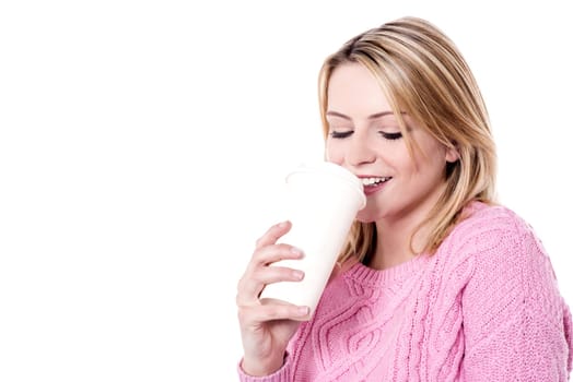 Young model in winter clothes enjoying coffee
