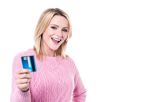 Cheerful young woman displaying credit card to camera