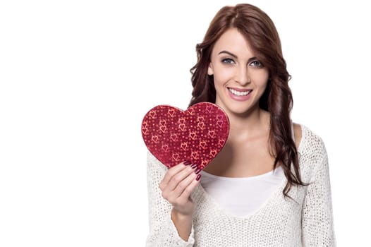 Smiling young girl showing heart shaped gift box