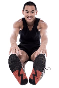 Young man sitting on the floor and doing exercise