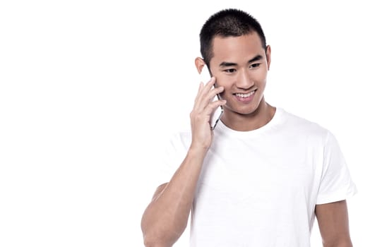 Handsome young man speaking on the phone over white