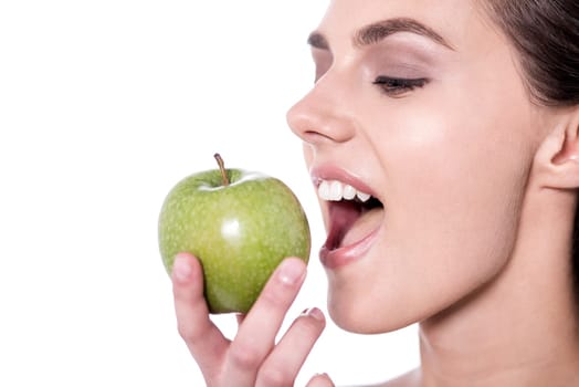 Young woman eating a green apple
