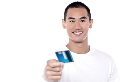 Young man displaying his debit card to camera