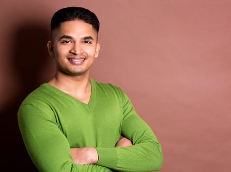 young casual man wearing green on brown background