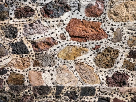 Detail of a stone wall made of various coarse stones.