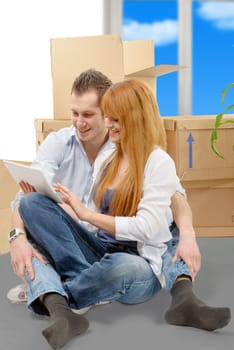 young couple arranging new apartment with digital tablet