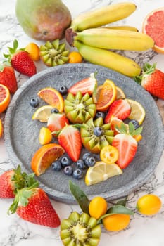 Colorful fruit salad on a rustic stone plate