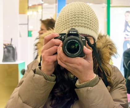 Moscow, Russia - January 05, 2016: A young girl takes a picture of the camera Nikon