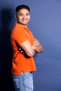 young casual man wearing orange tshirt on blue background