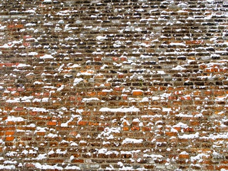 Detail of red brick and concrete wall lightly covered with snow flakes, winter time illustration, background, pattern