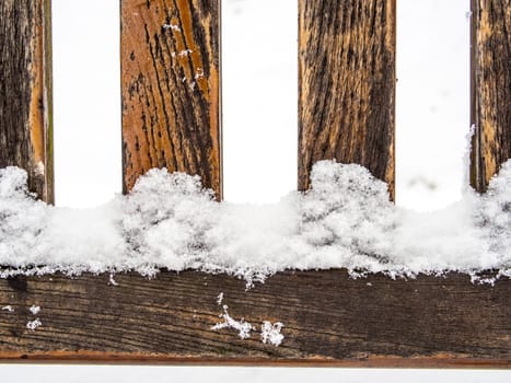 Detail of weathered wooden bench covered in snow, winter time illustration