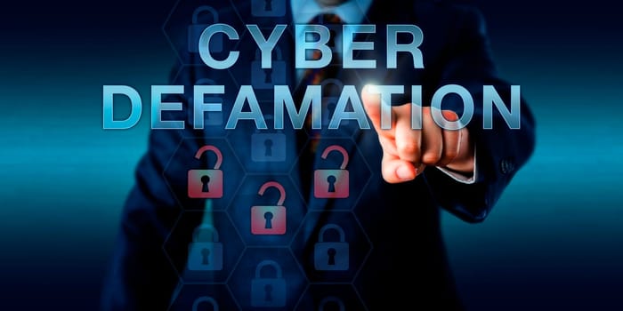 Legal consultant is touching CYBER DEFAMATION on a virtual interface. Information technology concept for defamation via malicious online commentary in forums, websites and internet portals.