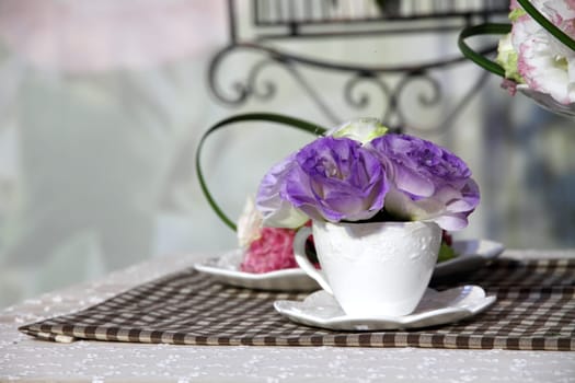 Brunch of blossom eustoma flowers in a white cup