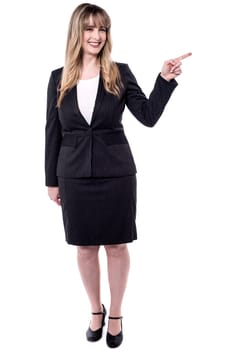 Smiling business woman pointing to copy space