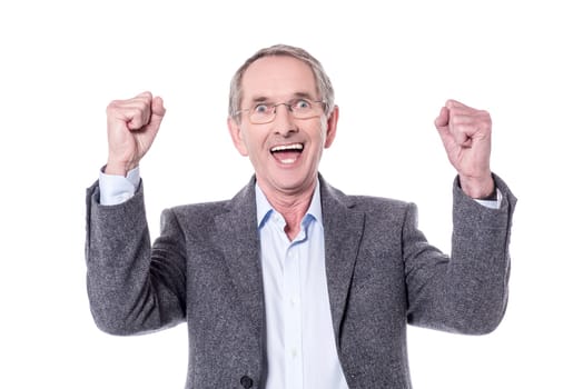 Cheerful senior man clenching his fists in joy.
