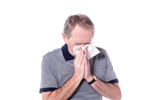 Senior man sneezing, suffering from cold.
