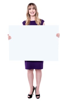 Middle aged woman holding blank ad board and posing to camera.