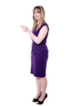 Full length of pretty model indicating towards copy space.