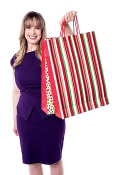 Pretty woman in party wear showing shopping bag