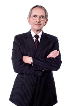 Aged businessman posing to camera with folded arms
