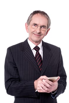 Confident aged businessperson messaging from his cellphone