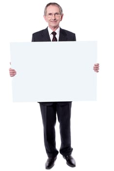 Handsome man holding blank white billboard. Showing to camera
