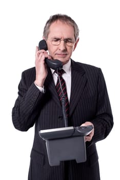 Senior businessman communicating in telephone over white
