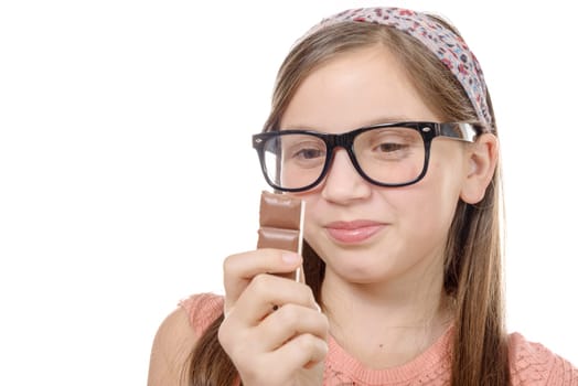 a preteen  girl eats chocolate, isolated on white