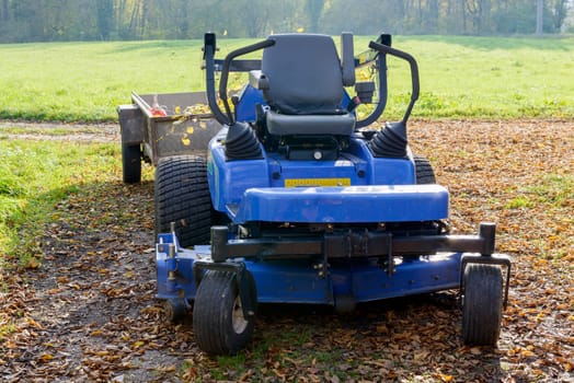 blue lawn mower in the middle of a meadow