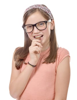 a preteen  girl eats chocolate, isolated on white