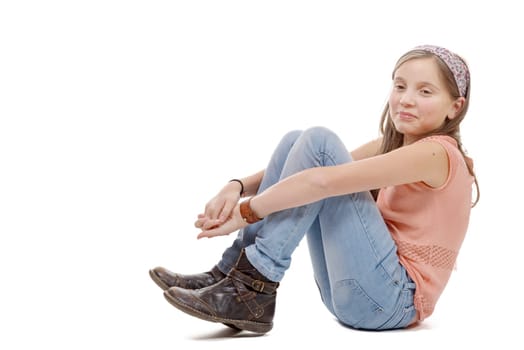 a young preteen sitting on the floor on white
