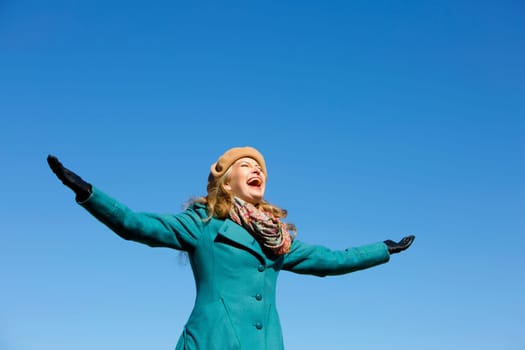 blond casual woman happy outdoors with blue sky