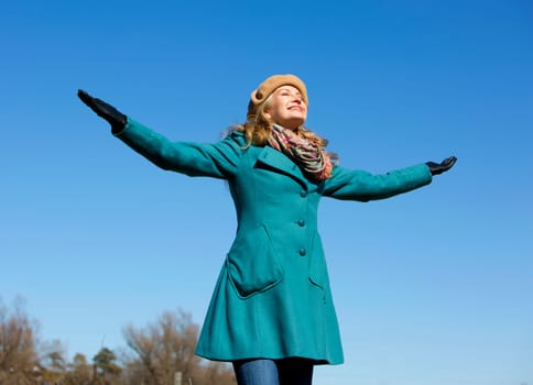 blond casual woman happy outdoors with blue sky