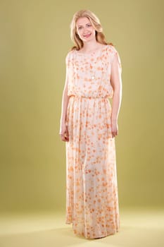 blond woman wearing beige dress on green background