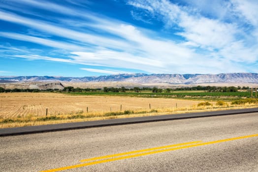 Highway passing through fields in Shell, Wyoming