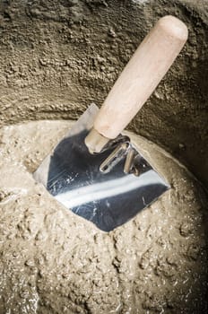 A bucket with a solution and a trowel, close-up