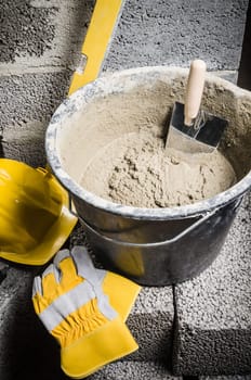 Tools for bricklayer bucket with a solution and a trowel, close-up