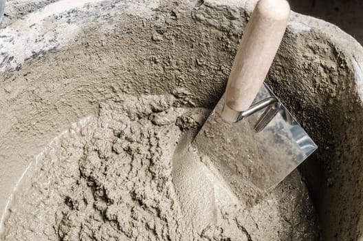 A bucket with a solution and a trowel, close-up
