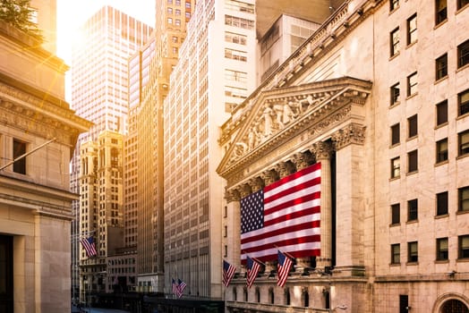 Famous Wall street and the building in New York, New York Stock Exchange with patriot flag