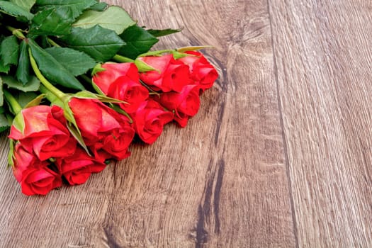 Red roses on a brown wooden background