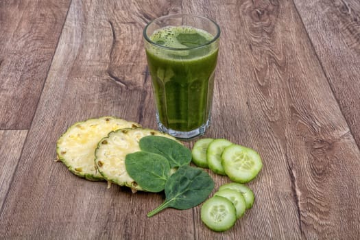 Blended fruit smoothie with ingredients on wooden table