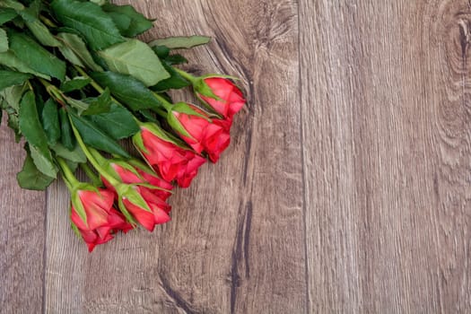 Red roses on a brown wooden background