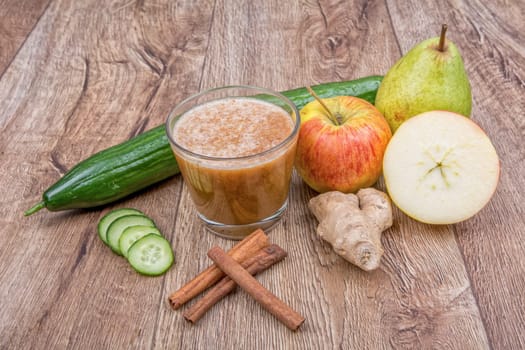 Blended fruit smoothie with ingredients on wooden table