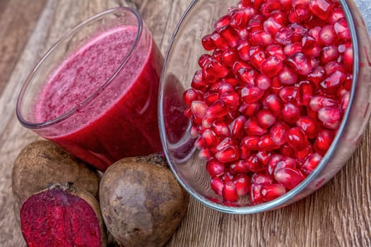 Blended fruit smoothie with ingredients on wooden table