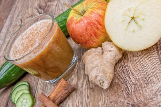 Blended fruit smoothie with ingredients on wooden table