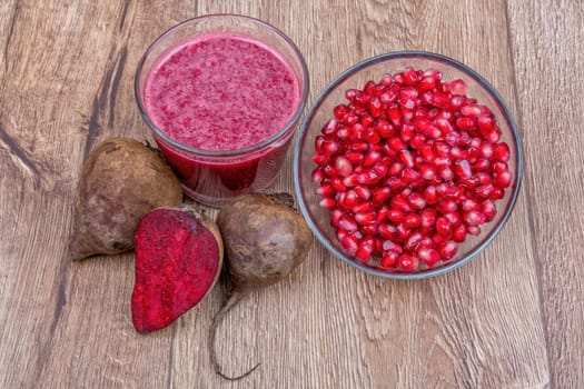 Blended fruit smoothie with ingredients on wooden table