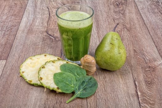 Blended fruit smoothie with ingredients on wooden table