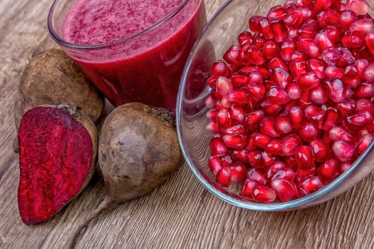 Blended fruit smoothie with ingredients on wooden table